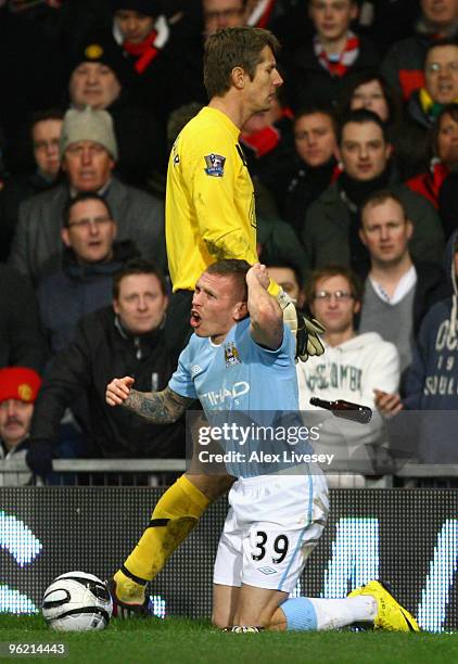 Craig Bellamy of Manchester City reacts after being hit by objects thrown from the crowd during the Carling Cup Semi Final second leg match between...