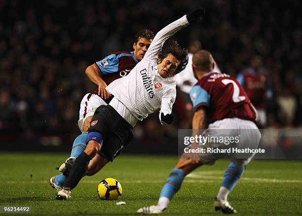 Tomas Rosicky of Arsenal is challenged from behind by Stiliyan Petrov of Aston Villa during the Barclays Premier League match between Aston Villa and...