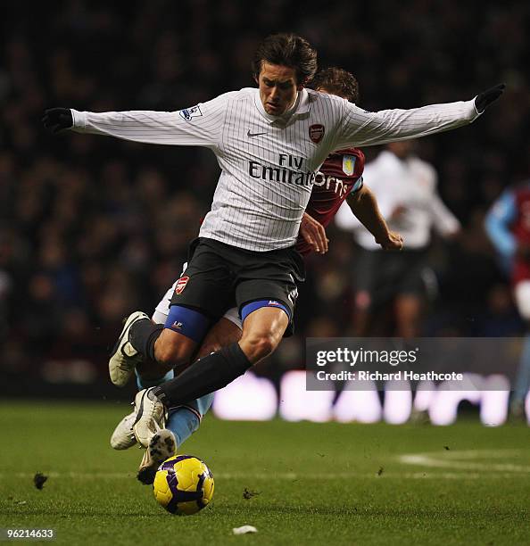 Tomas Rosicky of Arsenal is challenged from behind by Stiliyan Petrov of Aston Villa during the Barclays Premier League match between Aston Villa and...