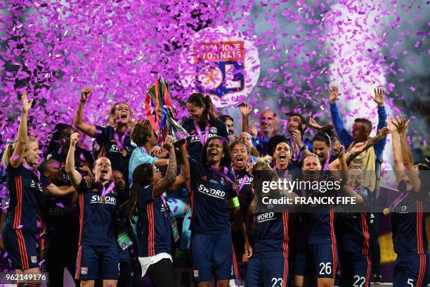 Olympique Lyonnais' French defender Wendie Renard holds the trophy with teammates as they celebrate their victory after the UEFA Women's Champions...