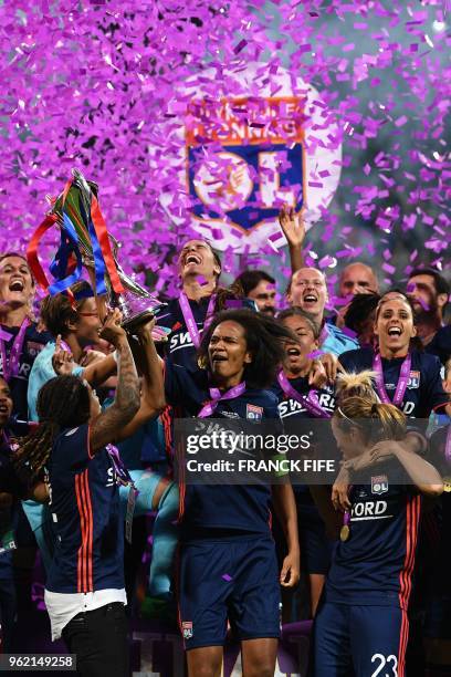 Olympique Lyonnais' French defender Wendie Renard holds the trophy with teammates as they celebrate their victory after the UEFA Women's Champions...