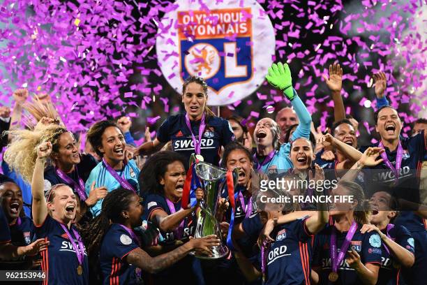 Olympique Lyonnais' French defender Wendie Renard holds the trophy with teammates as they celebrate their victory after the UEFA Women's Champions...