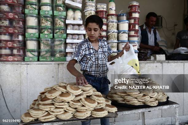 Syrian youth bags "Qatayef", traditional pancakes that are popular during the Muslim fasting month of Ramadan, in the northern town of al-Bab on May...
