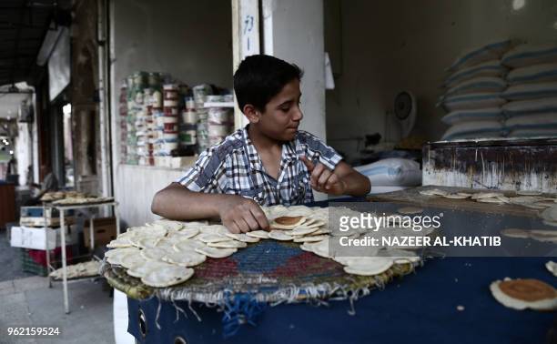 Syrian youth prepares "Qatayef", traditional pancakes that are popular during the Muslim fasting month of Ramadan, in the northern town of al-Bab on...