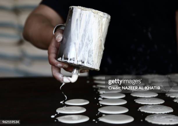 Syrian youth prepares "Qatayef", traditional pancakes that are popular during the Muslim fasting month of Ramadan, in the northern town of al-Bab on...