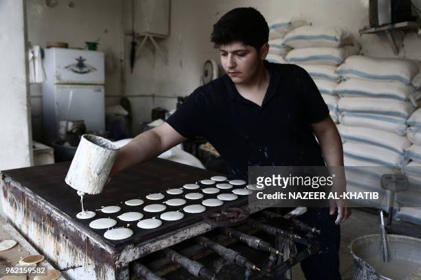 Syrian youth prepares "Qatayef", traditional pancakes that are popular during the Muslim fasting month of Ramadan, in the northern town of al-Bab on...