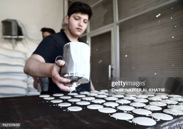 Syrian youth prepares "Qatayef", traditional pancakes that are popular during the Muslim fasting month of Ramadan, in the northern town of al-Bab on...