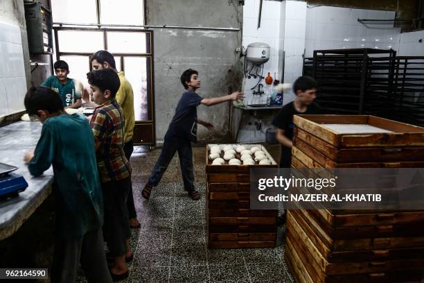 Syrian youth tosses dough during the preparation of "Maarouk", sweet pastries usually stuffed with dates or other sweet fillings consumed during the...