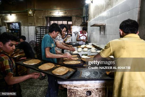 Syrians work in a bakery to prepare "Maarouk", a sweet pastry usually stuffed with dates or other sweet fillings consumed during the Muslim fasting...