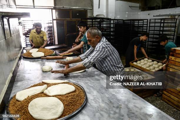 Syrians work in a bakery to prepare "Maarouk", a sweet pastry usually stuffed with dates or other sweet fillings consumed during the Muslim fasting...