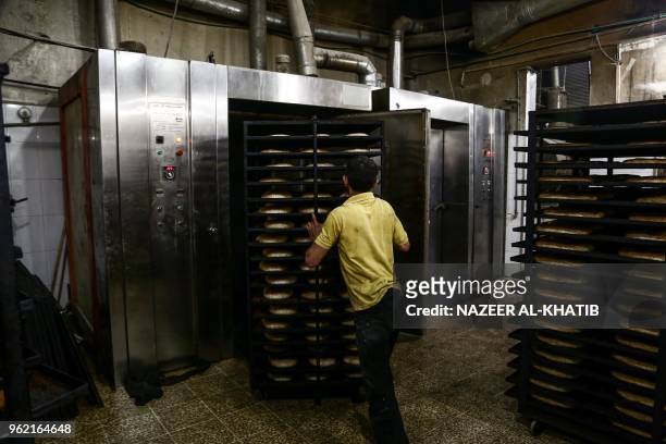 Syrian youth pushes trays of "Maarouk", sweet pastries usually stuffed with dates or other sweet fillings consumed during the Muslim fasting month of...