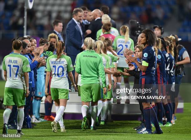 Olympique Lyonnais' French defender Wendie Renard and teammates applaud Wolfsburg player heading to the podium at the end of the UEFA Women's...