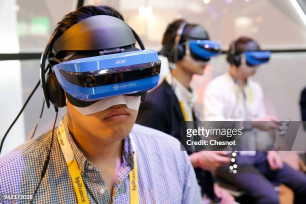 Visitors play a video game with the Acer Windows Mixed Reality Headset during the Viva Technologie show at Parc des Expositions Porte de Versailles...