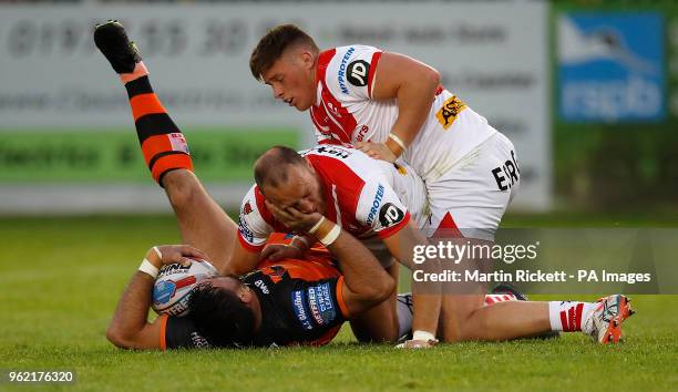 Castleford Tigers Matt Cook is tackled by St Helens' James Roby and Morgan Knowles during the Betfred Super League match at the Mend-A-Hose Jungle,...