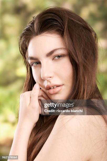 brunette woman with natural look and green eyes on nature background - diastema stock-fotos und bilder