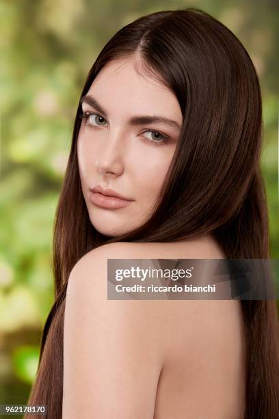 brunette woman with natural look and straight hair on nature backgrou - diastema stock-fotos und bilder