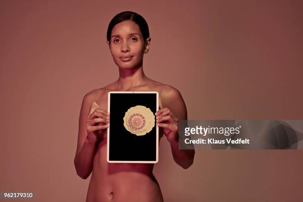 young woman holding tablet in front of breast - seno foto e immagini stock