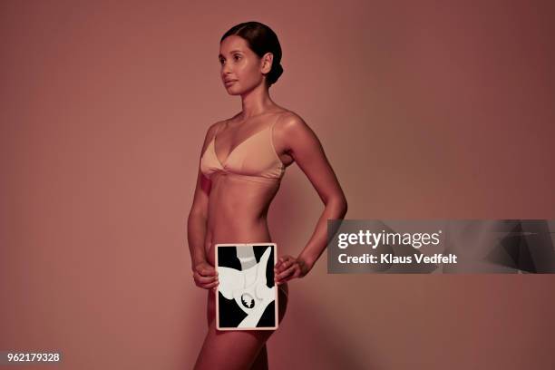 young woman holding tablet in front of body to display hip bone - hip bone stock-fotos und bilder