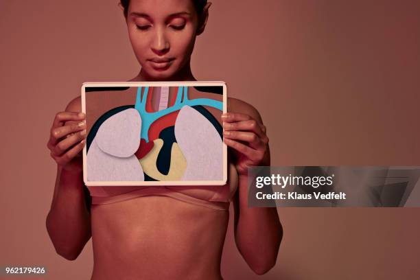 young woman holding tablet in front of throat to show oesophagus - intern menselijk orgaan stockfoto's en -beelden