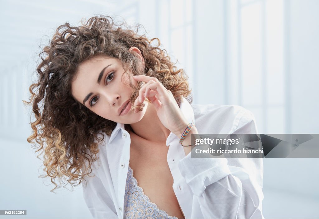 NATURAL LOOK WOMAN WITH CURLY HAIR WEARING A WHITE SHIRT
