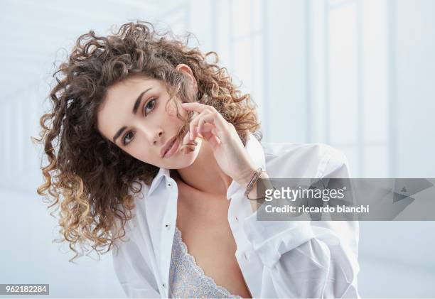 natural look woman with curly hair wearing a white shirt - curly hair - fotografias e filmes do acervo