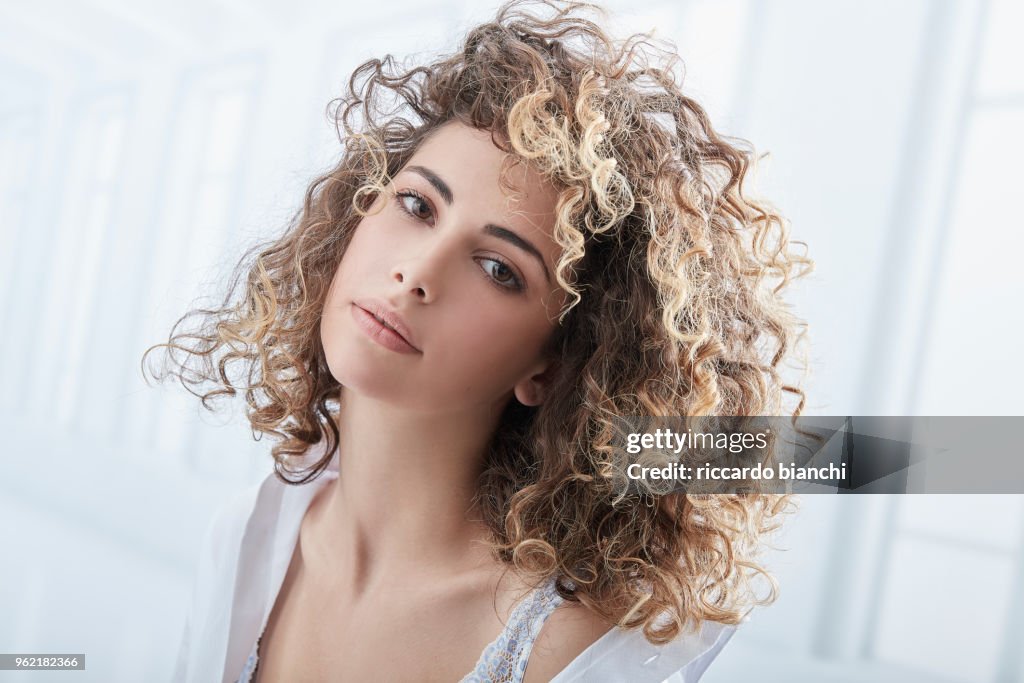 NATURAL LOOK WOMAN WITH CURLY HAIR WEARING A WHITE SHIRT