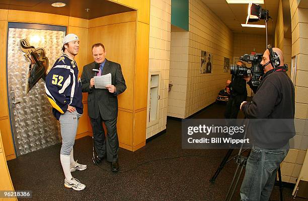 Craig Rivet of the Buffalo Sabres is interviewed outside the dressing room by Rob Ray of the MSG Network before playing the New Jersey Devils on...