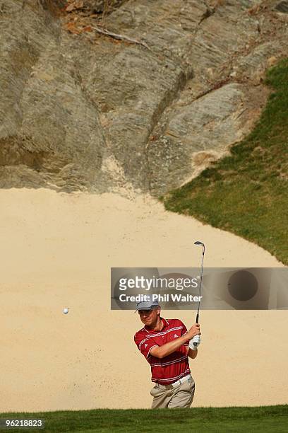 Scott Dunlap of the USA plays out of a bunker on the 17th hole during day one of the New Zealand Open at The Hills Golf Club on January 28, 2010 in...