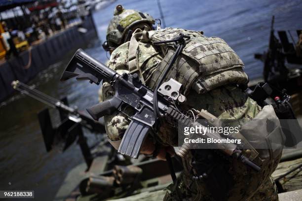 Navy Special Warfare Combatant-Craft Crewman secures a Special Operations Craft Riverine boat during an International Special Operations Forces...