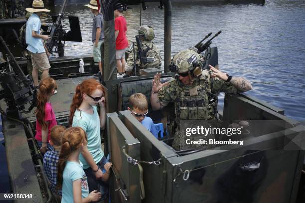 Navy Special Warfare Combatant-Craft Crewmen give attendees a tour of a Special Operations Craft Riverine boat after an International Special...