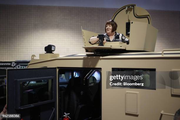 An attendee stands in the turret of a Lenco Industries Inc. Armored vehicle during the Special Operations Forces Industry Conference in Tampa,...