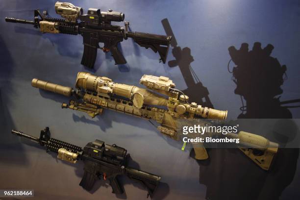 Military rifles are displayed at the L3 Technologies Inc. Booth on the exhibit floor during the Special Operations Forces Industry Conference in...