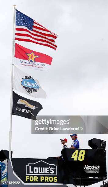 Jimmie Johnson, driver of the Lowe's Patriotic Chevrolet, and his crew chief Chad Knaus look on from the top of the team hauler during practice for...