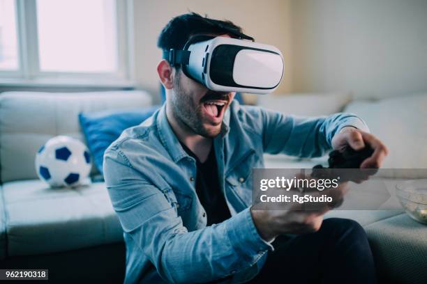 homme excité jouer à des jeux de réalité virtuelle - jeux vidéos photos et images de collection