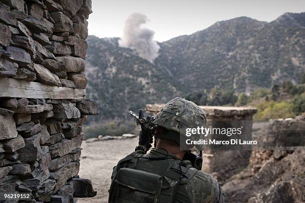 Army soldier from B Company, 2nd Battalion,12th Infantry Regiment, 4th Brigade,4th Infantry Division Baker Company is seen in the foreground of an...