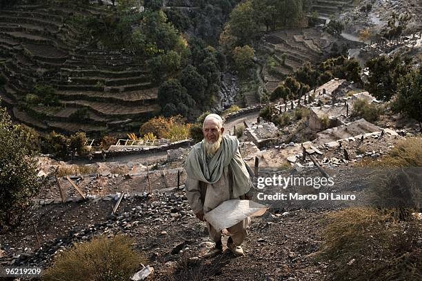 An afghan elderly arrives to attend the funeral of two children killed during an explosion as US Army soldiers of B Company, 2nd Battalion,12th...