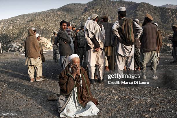 An afghan elderly pray before the funeral of two children killed during an explosion as US Army soldiers of B Company, 2nd Battalion,12th Infantry...