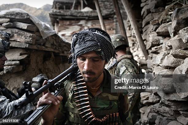 Afghan National Army Soldier, Akbar, 22-years-old holds a machine gun as he partecipates in an operation to secure the Korengal village with US Army...