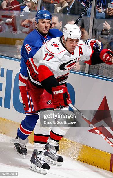 Sean Avery of the New York Rangers skates along the boards against Rod Brind'Amour of the Carolina Hurricanes on January 27, 2010 at Madison Square...