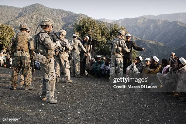 Afghan villagers are searched before the funeral of two children killed during an explosion by US Army soldiers of B Company, 2nd Battalion,12th...