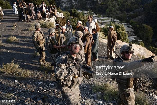 Afghan villagers are waiting to be search before the funeral of two children killed during an explosion as US Army soldiers of B Company, 2nd...
