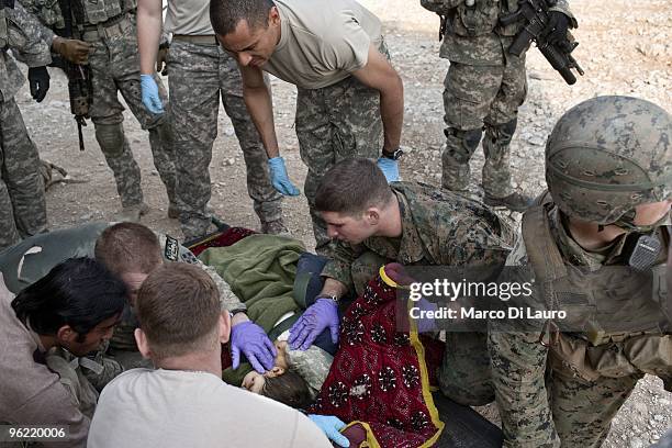 Army medics of B Company, 2nd Battalion,12th Infantry Regiment, 4th Brigade,4th Infantry Division Baker Company treat a wounded children at the...