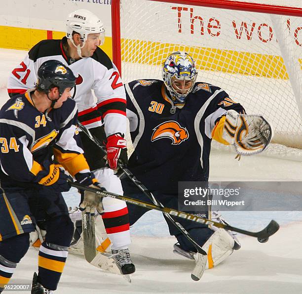 Ryan Miller and Chris Butler of the Buffalo Sabres stop Rob Niedermayer of the New Jersey Devils on January 27, 2010 at HSBC Arena in Buffalo, New...