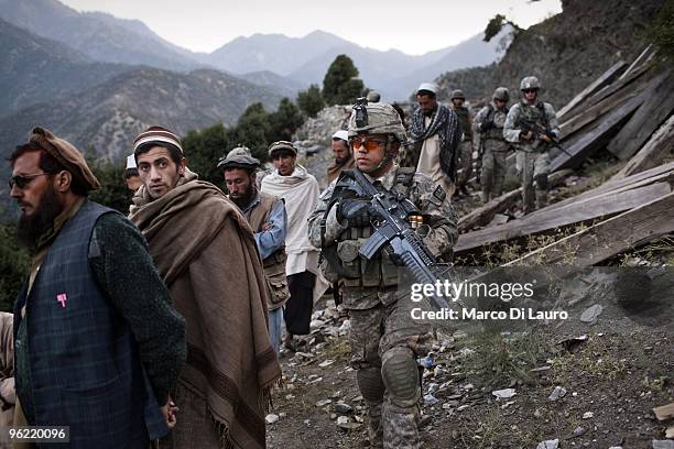 Afghan villagers walks as they are brought back by US Army soldiers of B Company, 2nd Battalion,12th Infantry Regiment, 4th Brigade, 4th Infantry...