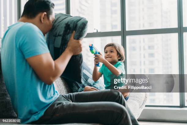 malaysian dad playing with his child - bb gun stock pictures, royalty-free photos & images