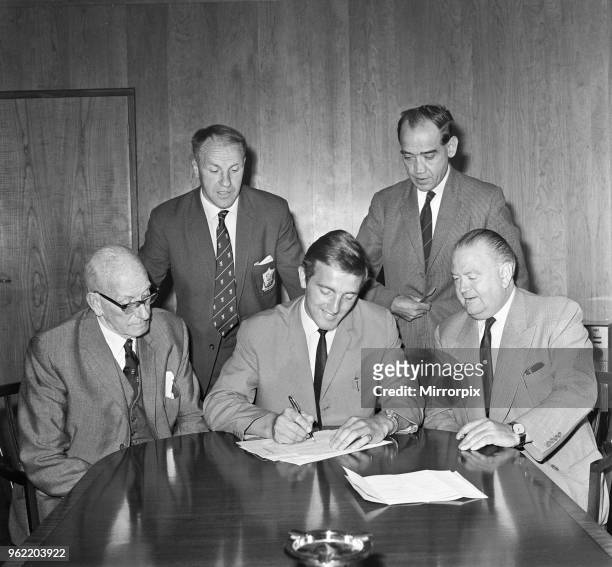 Footballer Peter Thompson signs for his new club Liverpool after his £37,000 transfer from Preston North End. Watching on for Liverpool are Bill...
