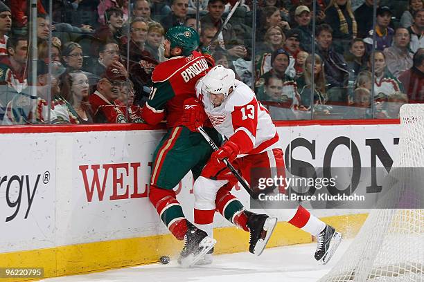 Kyle Brodziak of the Minnesota Wild is checked by Pavel Datsyuk of the Detroit Red Wings during the game at the Xcel Energy Center on January 27,...