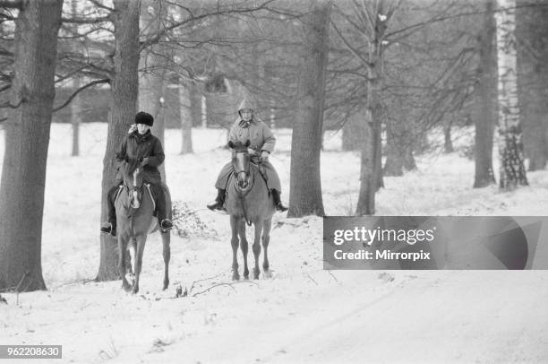 The Royal Family at Christmas and New Year. Queen Elizabeth II and Princess Anne, out riding their horses in the snow, during their New Year holiday...