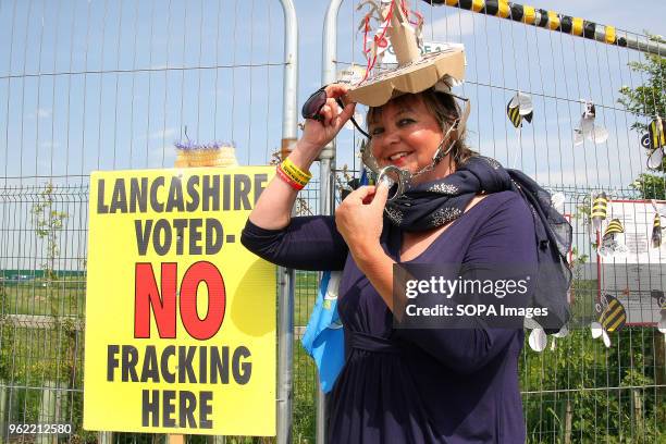 An Anti-Frack Protester with a "Tree Sculpture Hat" adorned with Handcuffs poses at the security fence of Fracking company "Cuadrilla's" Frack site...