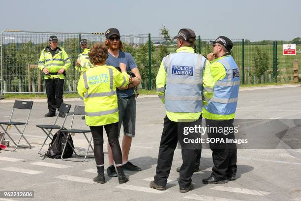 Polite Protector" one of an army of Anti-Fracking Volunteers, with Police Liaison Offers looking on, talks to a Protestor and his dog as the try to...